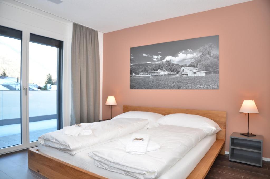 因特拉肯Apartment Anemone - GriwaRent AG的一间卧室设有一张大床和一个大窗户