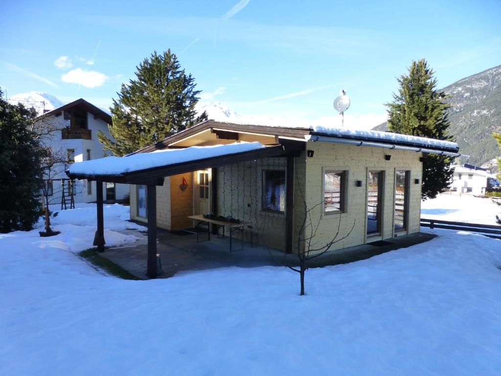 皮茨河谷阿兹尔Chalet Auszeit的雪上覆盖着雪盖的小房子