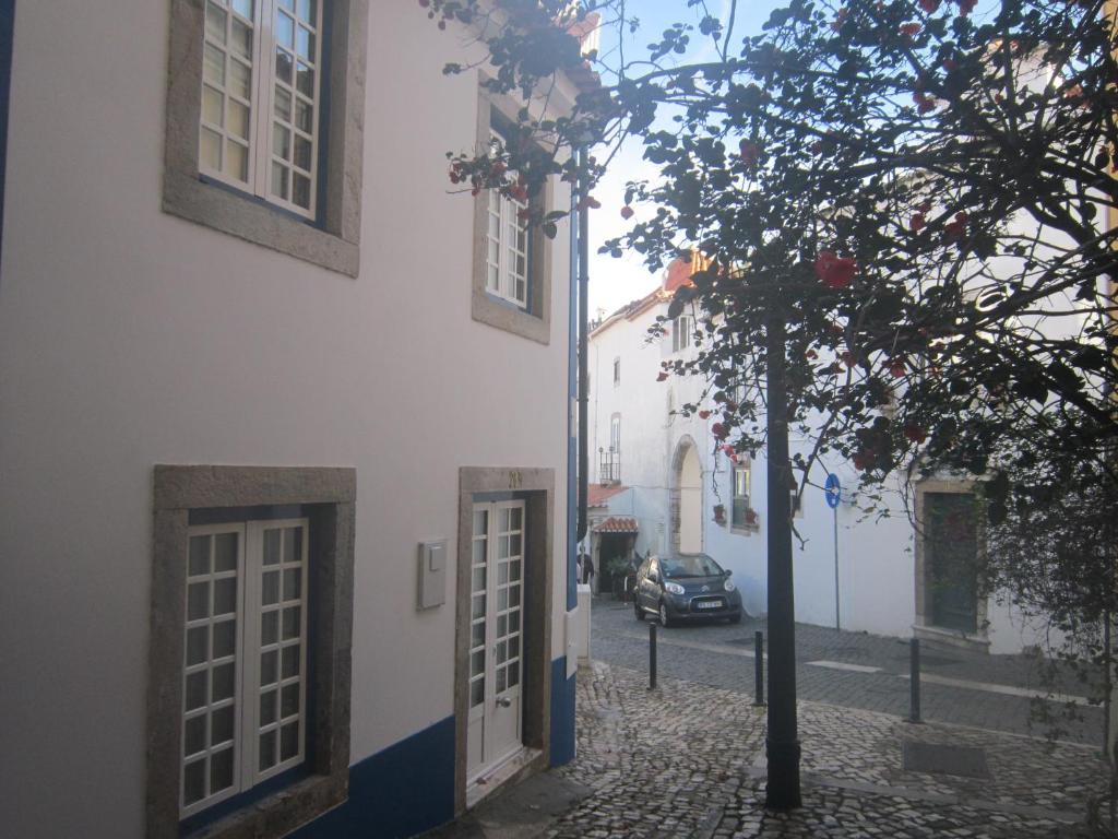 卡斯卡伊斯Casa Zé Bonito II的街道旁有门和树的建筑