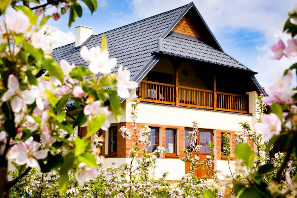 卡齐米日-多尔尼Agroturystyka Pod Jabłonią的一座黑色屋顶和粉红色花卉的房子