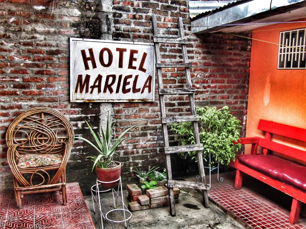 埃斯特利Hostal Mariella的砖墙旁边的酒店市场标志