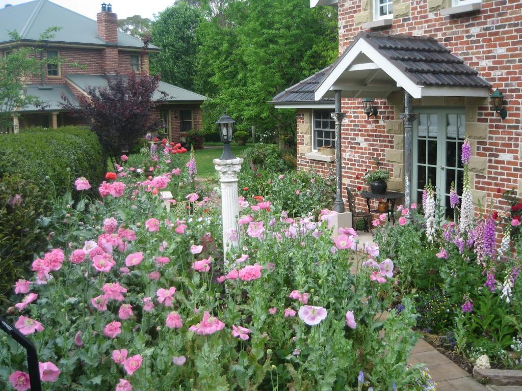 Kurrajong安妮小屋旅馆的砖屋前有粉红色花的花园