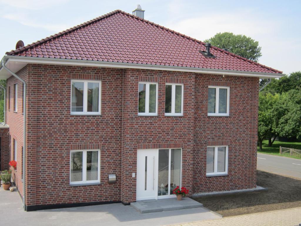 森登霍尔斯特Ferienwohnung de Jong的红砖房子,设有白色窗户