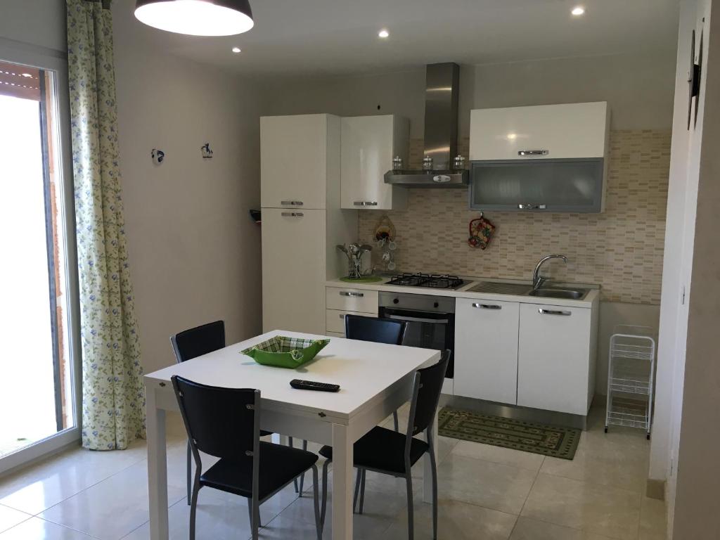 塔维亚诺appartamento Luigi的厨房配有白色的桌椅和水槽