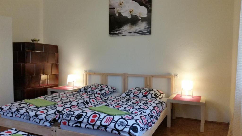 卢布尔雅那Sašo Rooms & Apartments的一间卧室配有一张床、两张桌子和两盏灯。
