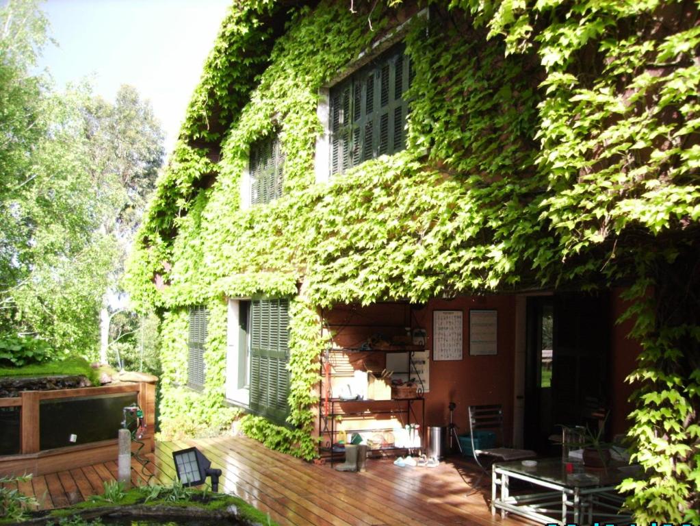 埃尔纳尼Casa Rural Arraigorri的一座常春藤覆盖的建筑,设有木甲板
