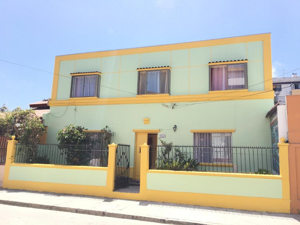 拉塞雷纳Hostal Luna del Mar的黄色和白色的房子,带围栏