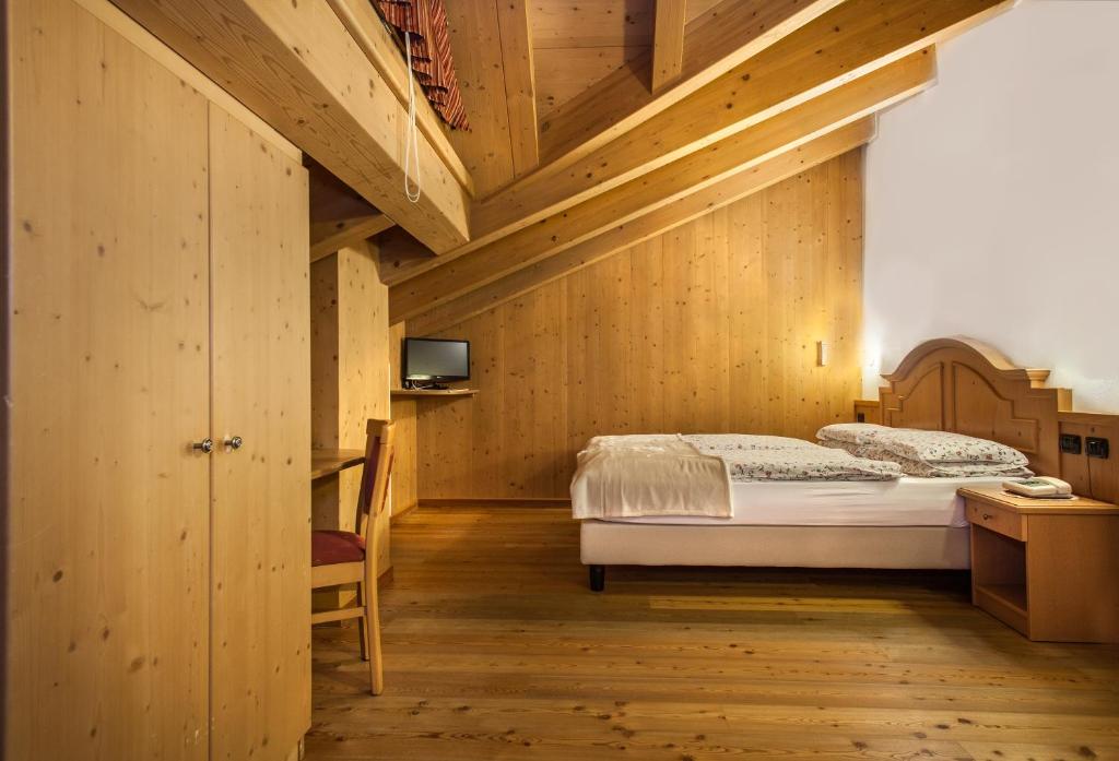 圣卡特琳娜瓦尔夫潘德兰奇尼酒店的一间卧室设有一张床和木制天花板