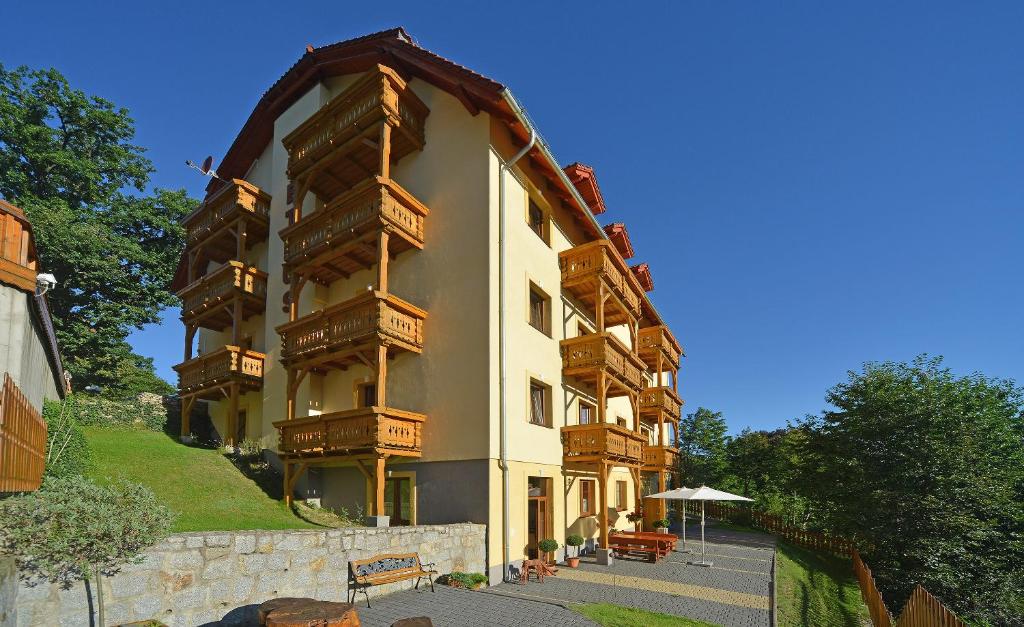 卡尔帕奇薇拉佩特鲁斯酒店的一座大型建筑的侧面设有木制阳台