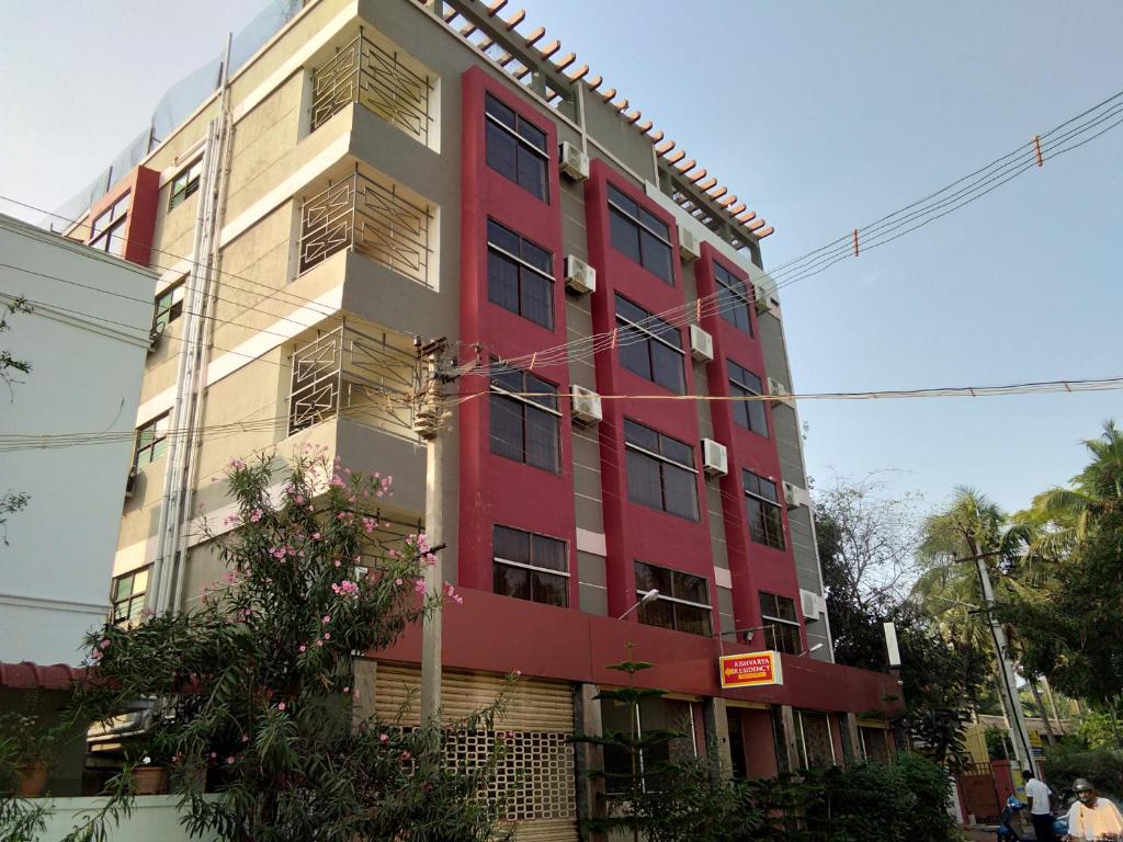 哥印拜陀Aishvarya Residency Coimbatore的街道边的红白色建筑