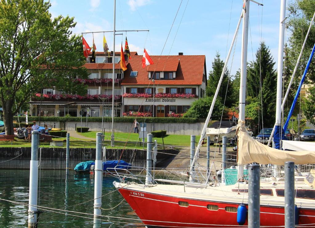 康斯坦茨博登湖兰德酒店的停靠在大楼前码头的一艘红船