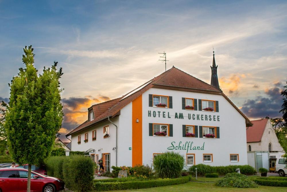 Röpersdorf昂克塞酒店的一座白色和橙色的建筑,带有教堂