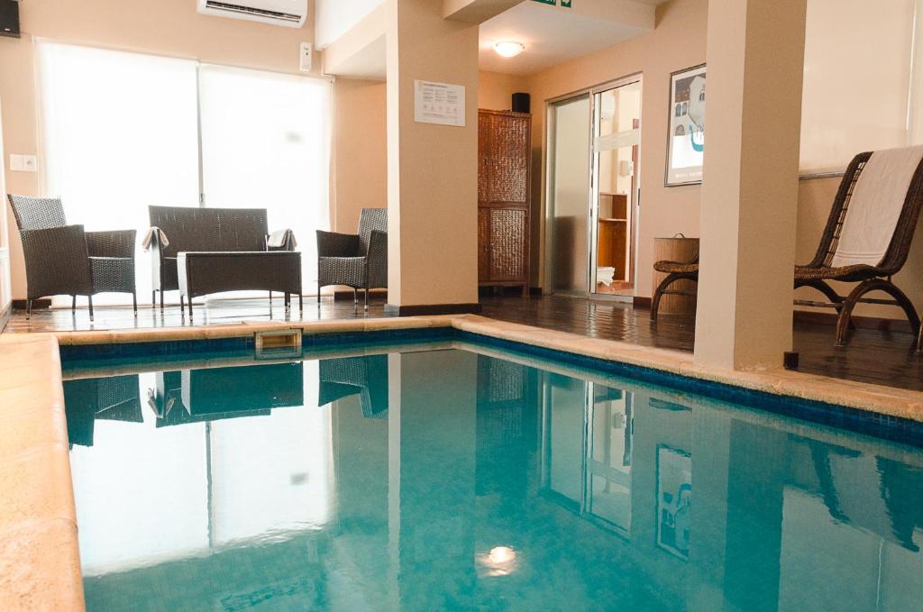 埃斯特角城日落海滩酒店 的一座配有桌椅的酒店游泳池