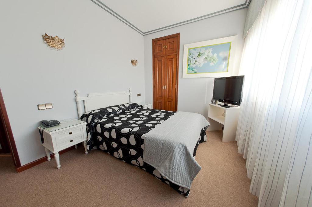 波伊奥唐佩皮酒店的一间卧室设有黑白床和电视。