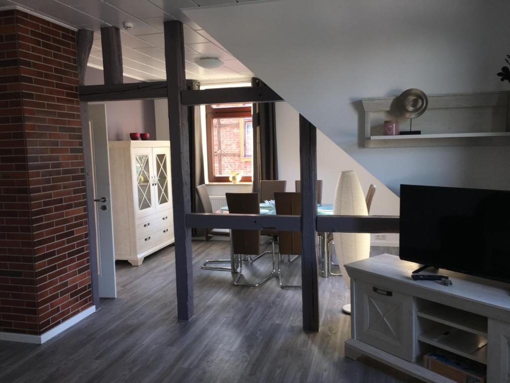 韦尼格罗德Harzer Ferienlodge的客厅设有楼梯、桌子和电视