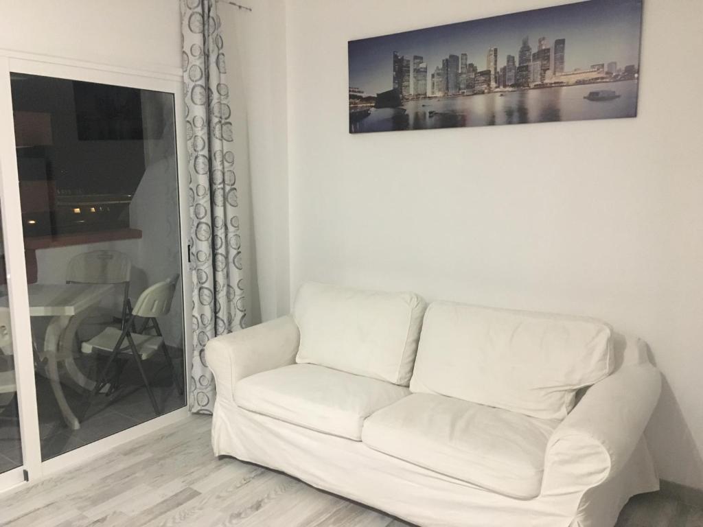 阿罗纳Tajinastes的客厅里的白色沙发,墙上挂着一幅画