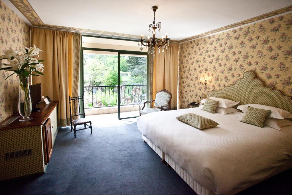Bresson沙凡特餐厅酒店的一间卧室设有一张大床和一个大窗户