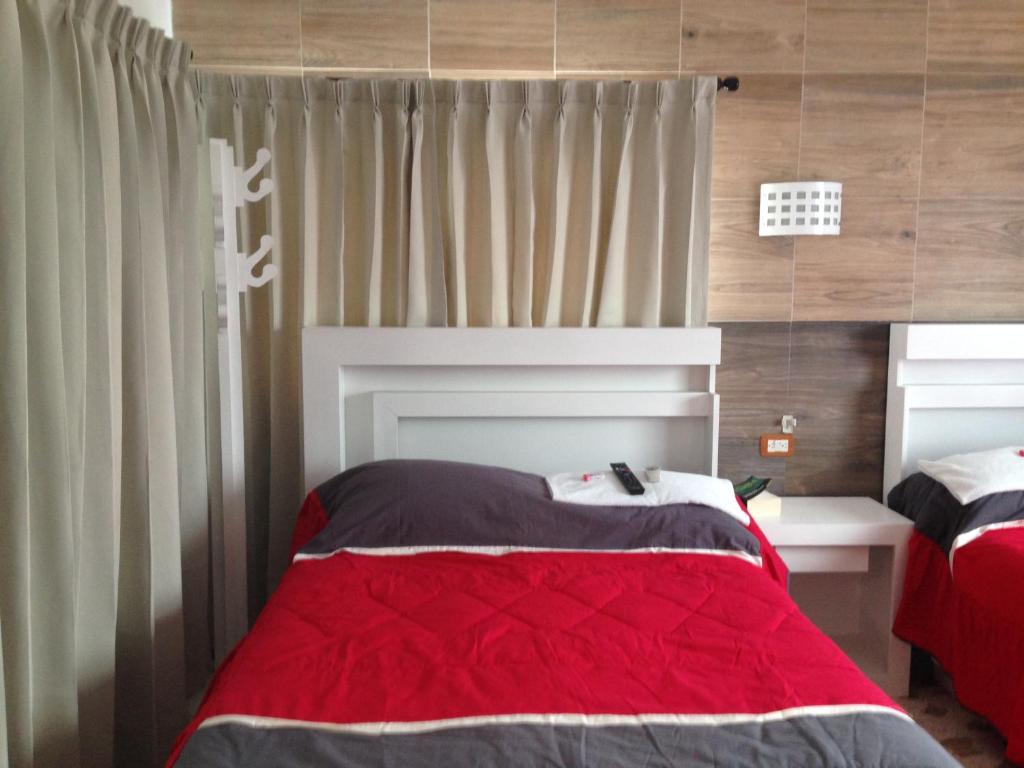 MacuspanaHotel Claudia的一间卧室配有一张带红色毯子的床