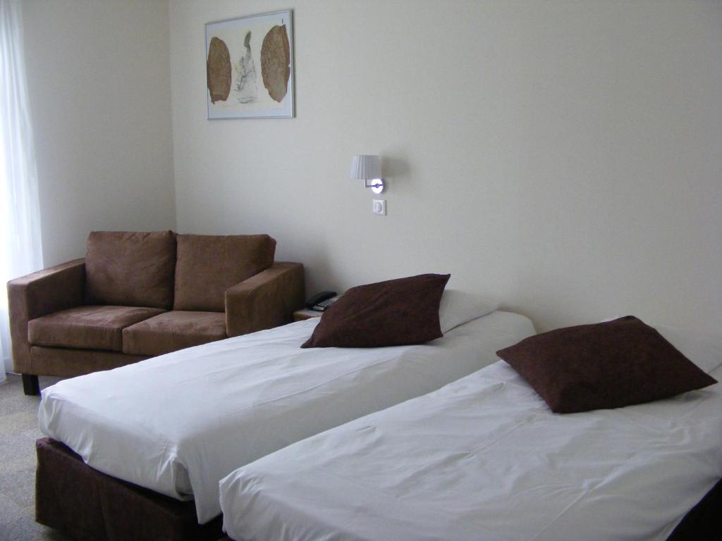 AnglesAuberge De Moricq的酒店客房,设有两张床和一张沙发