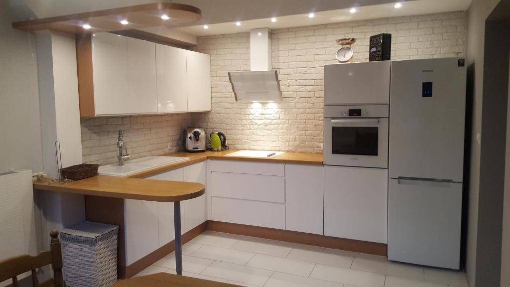 波兰尼卡-兹德鲁伊Apartament na Wolanach的厨房配有白色橱柜和白色冰箱。