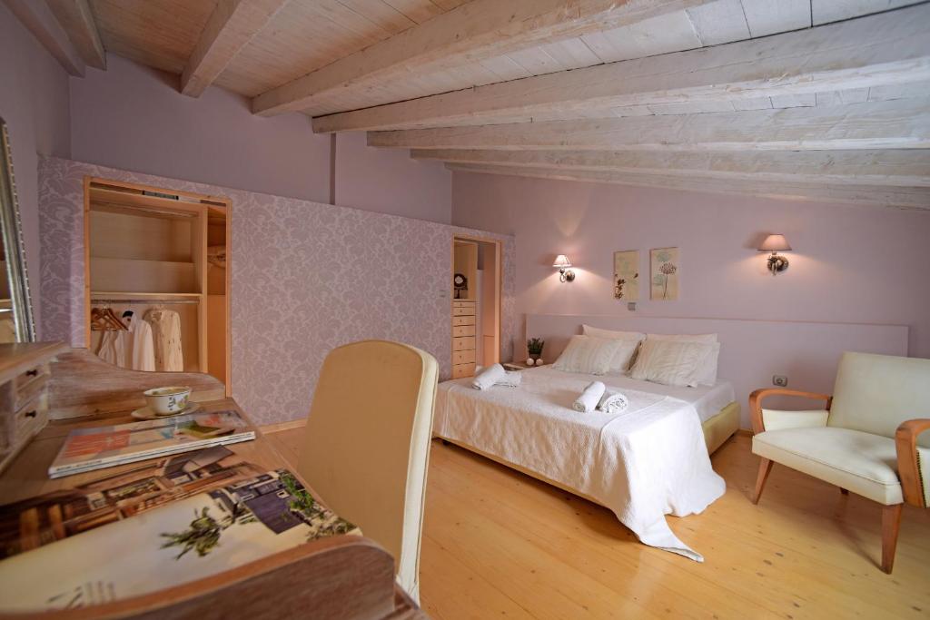 圣马太奥斯Glavounos House的卧室配有白色的床和椅子