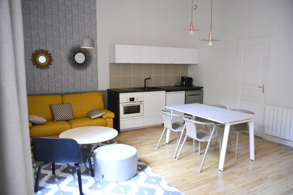 里昂Cosy apartment ideally located in the Old Town的厨房以及带黄色沙发和桌子的客厅。