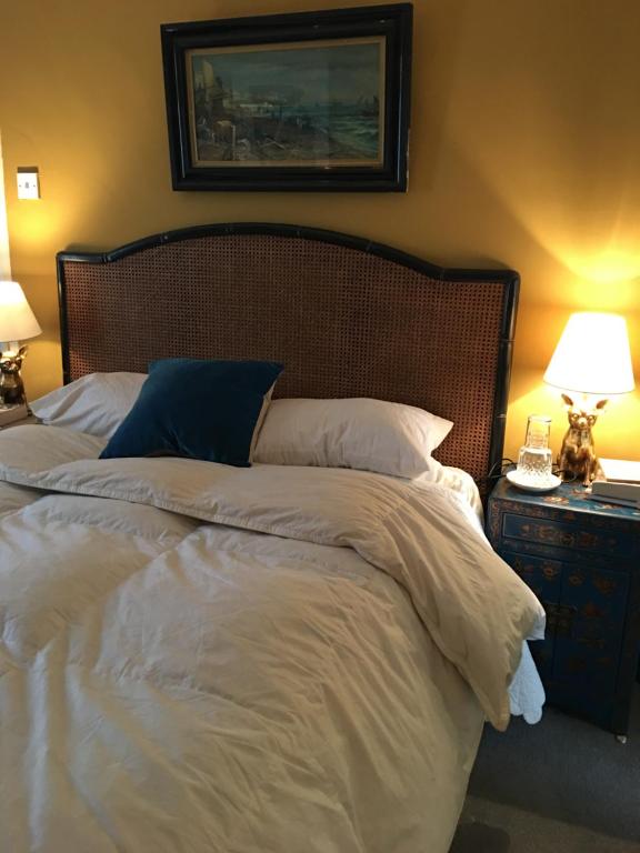 斯旺西Wynberg House Bed & Breakfast的一间卧室配有一张带白色床单和两盏灯的大床