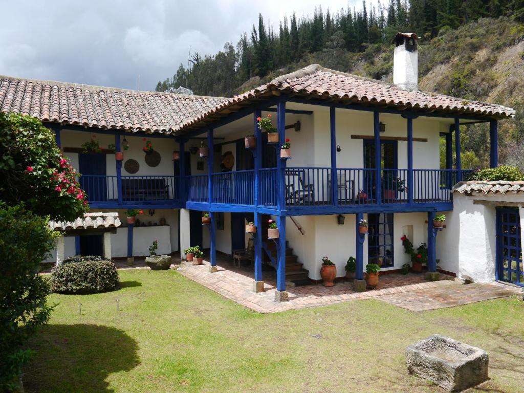 UbatéPosada El Molino de San Luis的蓝色阳台和庭院的房子
