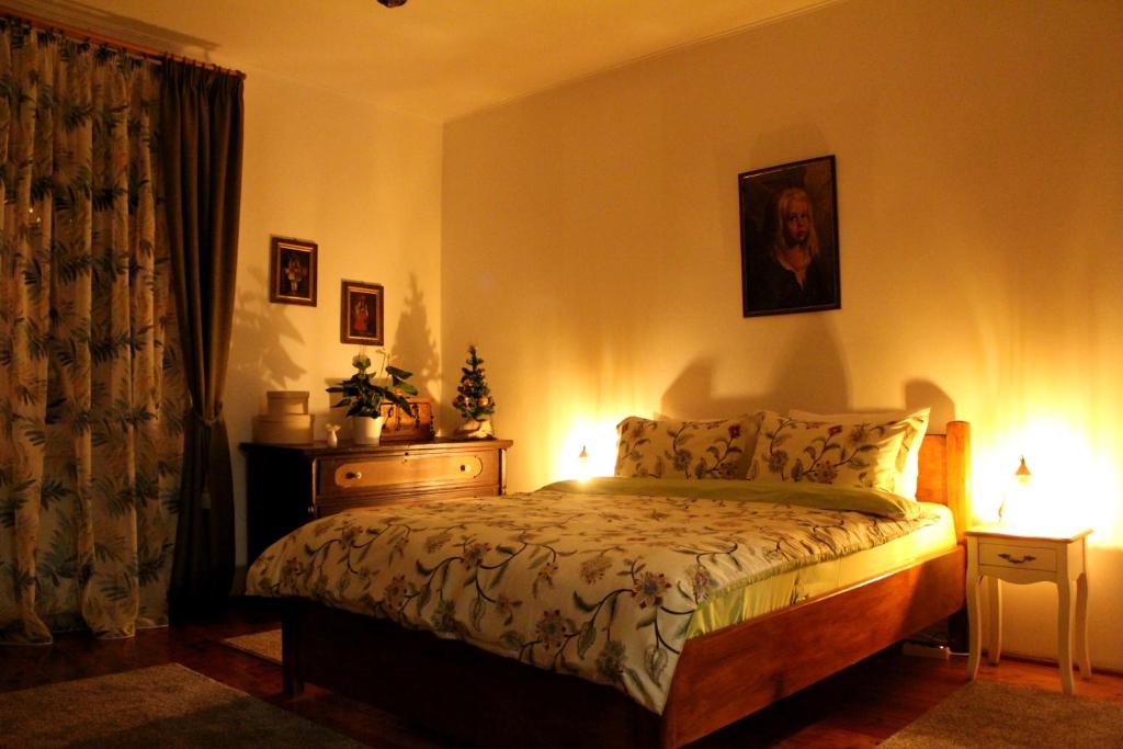 锡比乌La Bella的一间卧室配有床和一个带灯的梳妆台。
