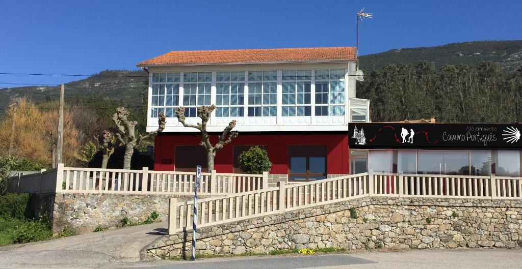 VilladesusoAlojamiento Camino Portugues Oia的白色的红色建筑,有白色的栅栏
