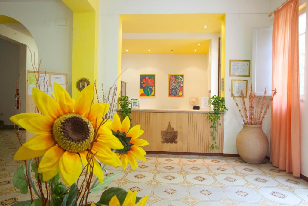 瓜迪亚皮耶蒙特泰尔梅Hotel Moderno的大厅,在房间中间有黄色的花