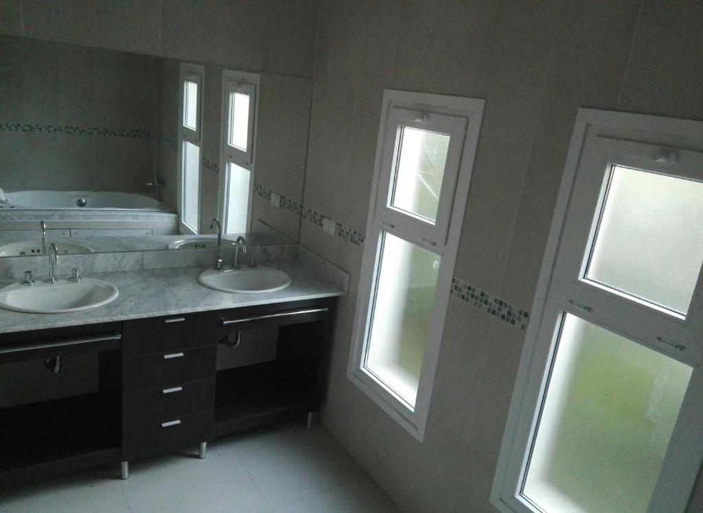 坦迪尔Hosteria Ruphay的一间带两个盥洗盆和两个窗户的浴室