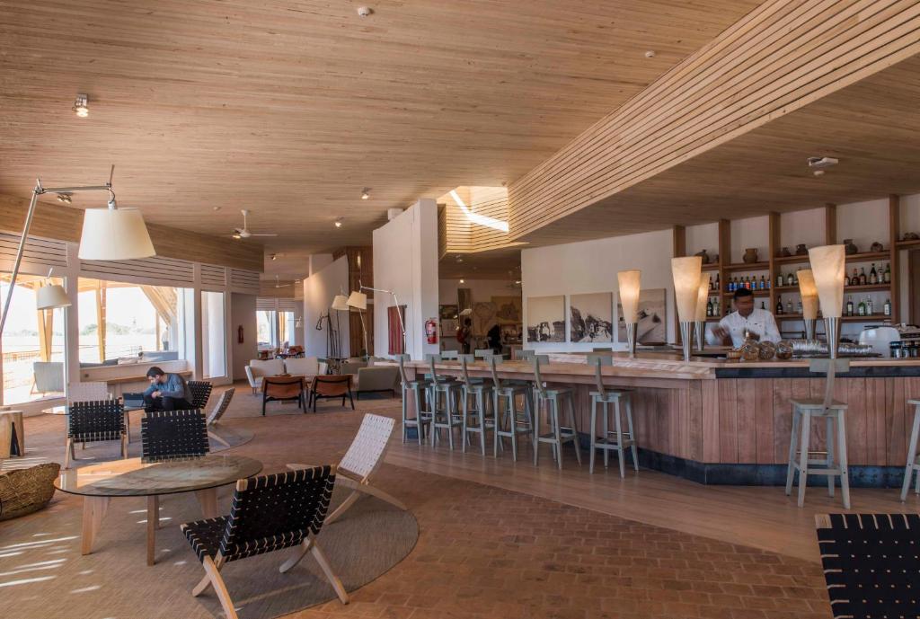 圣佩德罗·德·阿塔卡马Explora en Atacama - All Inclusive的餐厅设有酒吧,配有桌椅