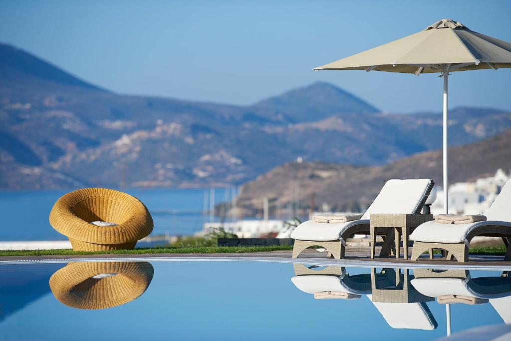 阿达玛斯Santa Maria Village Resort & Spa的一个带椅子和遮阳伞的游泳池以及游泳池