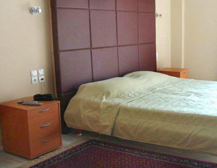 雅典雅典艺术套房酒店的一间卧室配有一张床和一个木制梳妆台
