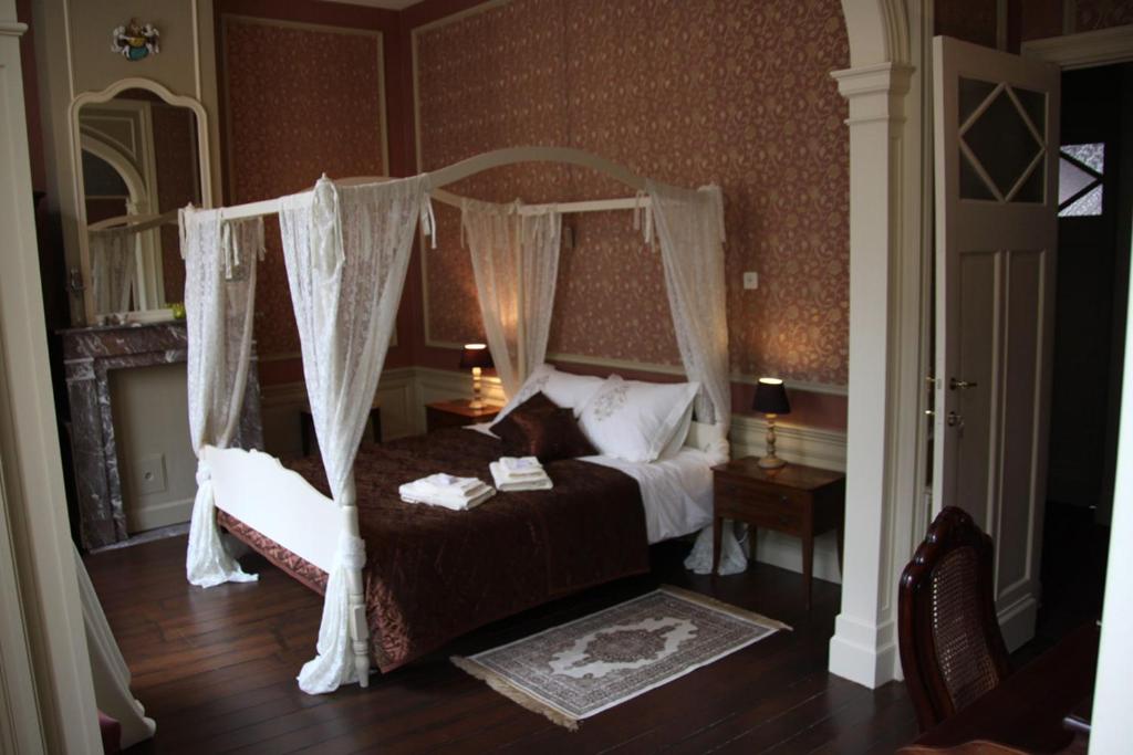 伊普尔La Porte Cochère的一间卧室配有一张带天蓬的床