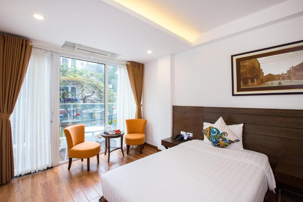 河内升龙西班牙酒店 的酒店客房带床、椅子和窗户