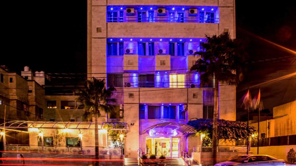 安曼阿哈蒂尔酒店的一座晚上有蓝色灯光的建筑