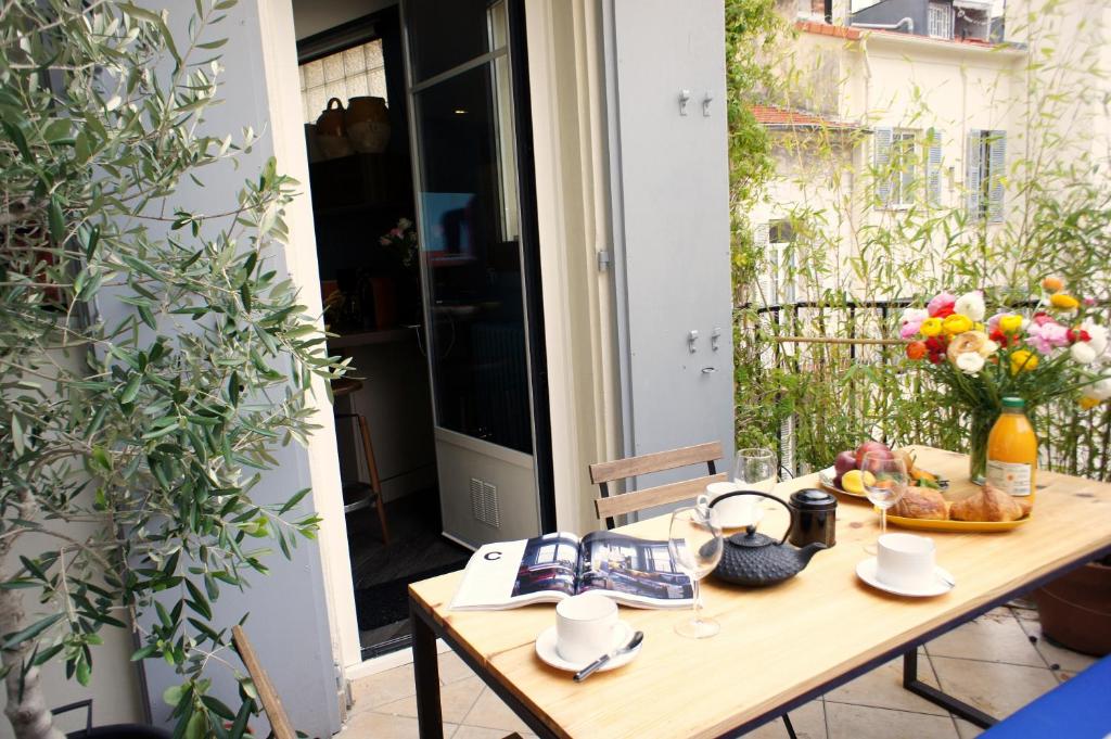 尼斯Ze Perfect Place - Élégant appartement avec terrasse - Promenade des Arts的庭院里的木桌,插着花