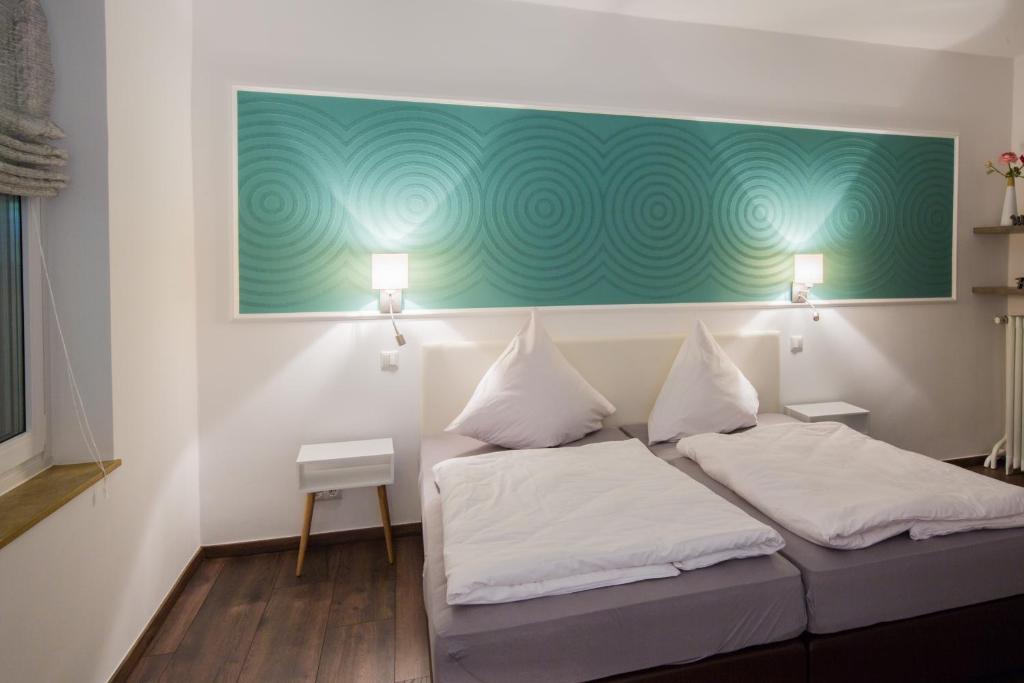 奥斯特霍尔茨-沙姆贝克Hotel Zur Alten Börse的客房设有两张床,墙上挂有绿色的画作