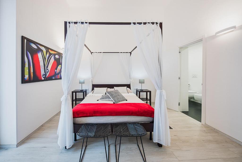莱切La casa di Giovanni的一间卧室配有一张带红色毯子的天蓬床