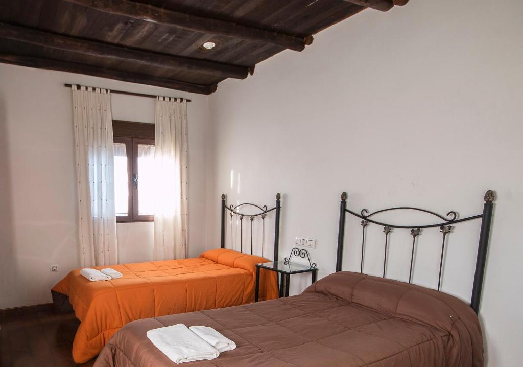 CantagalloEl Tirol的一间卧室配有两张带橙色床单的床