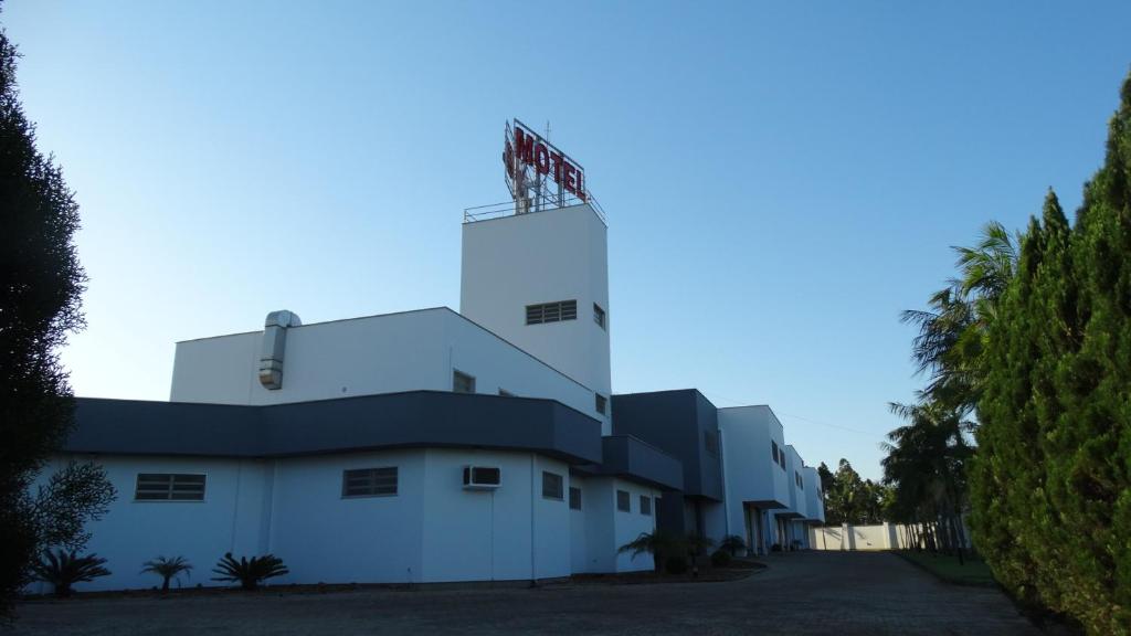 克里西玛紫浓汽车旅馆（仅限成人）的上面有旗帜的白色建筑