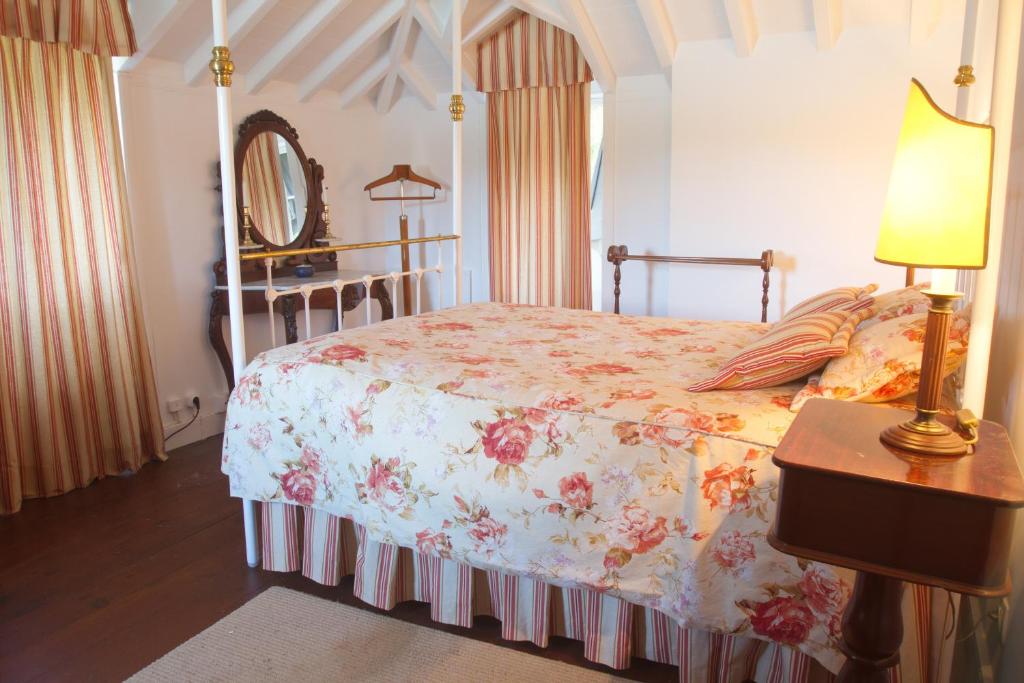 富尔纳斯Casa da Lagoa的一间卧室配有一张床、一盏灯和一面镜子