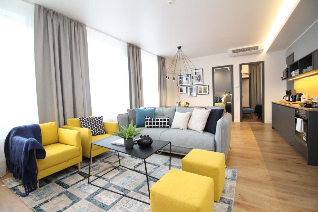 塔林老城套房塔林城市公寓式酒店的带沙发和黄色椅子的客厅