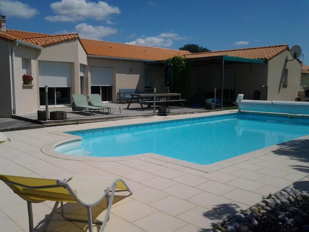 帕尔特奈La Chambre des Amis的房屋旁的游泳池配有桌椅