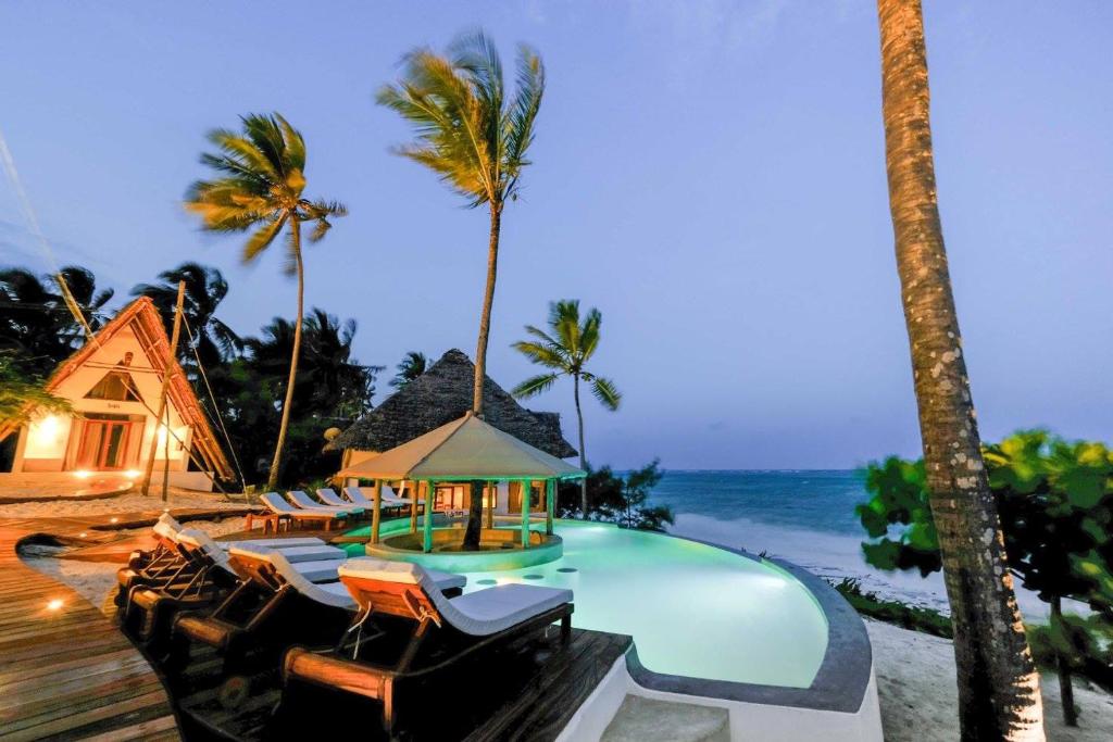 米查维巴拉丁桑给巴尔海滩酒店的一个带游泳池、椅子和棕榈树的度假村
