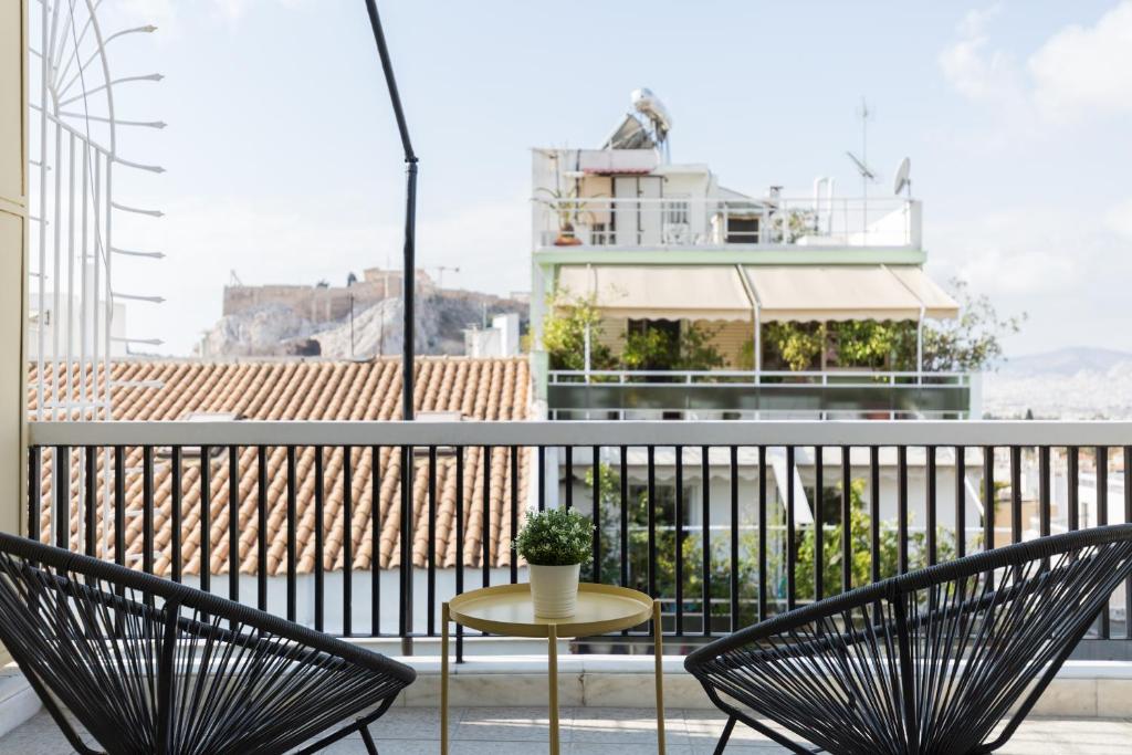 雅典Central Cozy Apartments in Plaka by UPSTREET的阳台的天井配有2把椅子和1张桌子