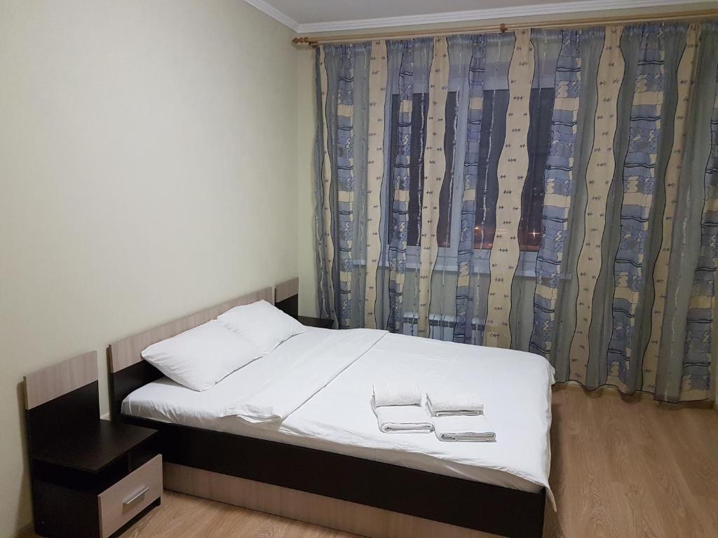 晓尔科沃Щёлковские квартиры - Богородский 2的一间卧室配有一张带白色床单的床和一扇窗户。