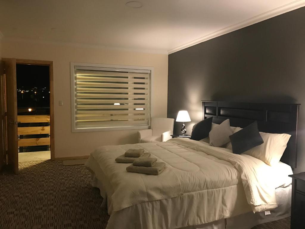 纳塔列斯港SHEUEN PATAGONIA的一间卧室配有一张大床和毛巾